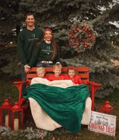 The Turner kids bundled under a blanket on the red bench